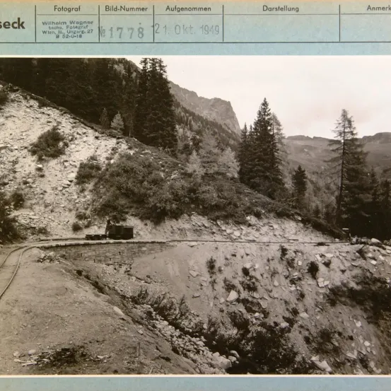Ein Schwarz-Weiß-Foto einer bergigen Landschaft mit einem kleinen Zug auf den Gleisen. Das Foto wurde am 21. Oktober 1949 in Wien, Österreich, aufgenommen.