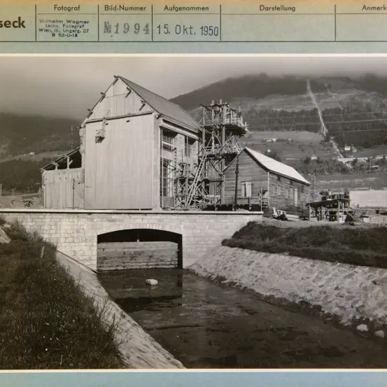 Ein Schwarz-Weiß-Foto eines Wassermühle mit einer Brücke und einem Fluss im Hintergrund. Das Bild trägt den Titel 'Fotograf' und die Nummer '1994'. Das Datum ist 15. Oktober 1950.