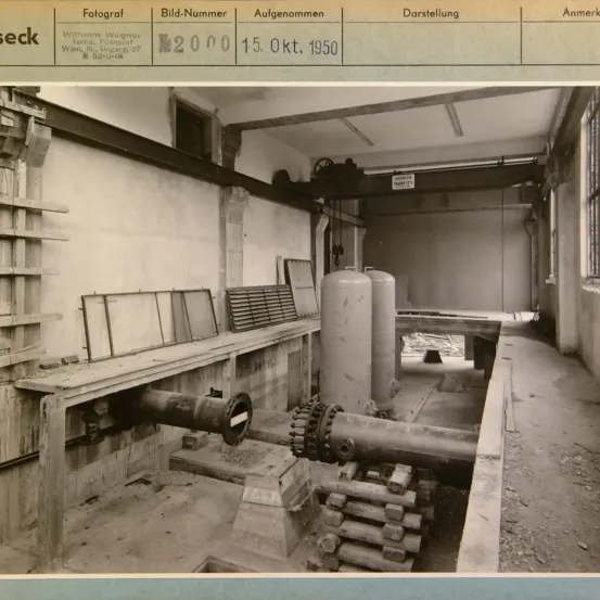 Ein Schwarz-Weiß-Foto eines Industriegeländes, aufgenommen am 15. Oktober 1950. Das Foto zeigt Rohre, Tanks und Maschinen in einem Raum.