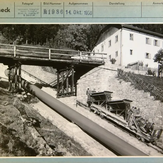 Ein Bild eines Pipelinebaustellen mit einem Haus und einer Brücke im Hintergrund. Das Bild hat eine Bildunterschrift, die 'Foto Nr. 1986, 14. Okt. 1950' lautet.