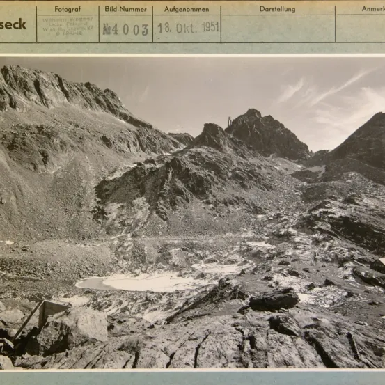 Schwarz-Weiß-Foto einer Berglandschaft mit einem kleinen Teich, aufgenommen am 18. Oktober 1951. Der Fotograf ist Wilhelm Wagner.