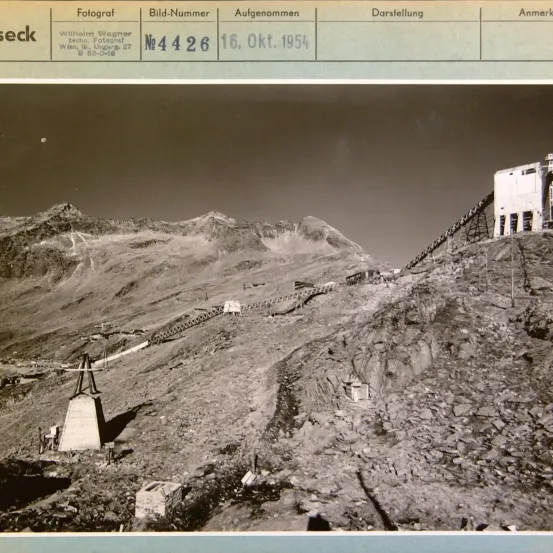 Das Bild zeigt ein bergiges Gelände mit einer Struktur auf der rechten Seite, wahrscheinlich ein Aussichtspunkt. Auf der linken Seite befindet sich ein Vermessungsinstrument. Das Datum 16. Okt. 1954 und die Bildnummer N4426 sind angegeben.
