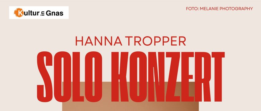 A woman is playing a cello in a solo concert, smiling and looking at the camera. The poster is in red and white.