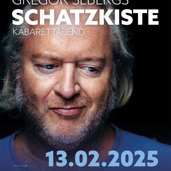 Plakat für Gregor Sebergs Schatzkiste Kabarettabend am 13. Februar 2025. Das Plakat zeigt eine Nahaufnahme eines älteren Mannes mit Bart, der ein blaues Hemd trägt, mit einem ernsten Gesichtsausdruck.