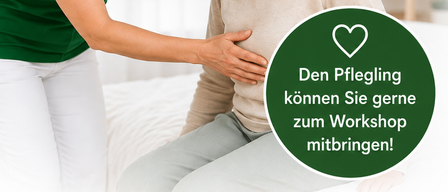 Eine Frau in einer grünen Uniform hilft einer älteren Frau mit einem Lächeln im Gesicht. Die ältere Frau sitzt auf einem Bett mit einem weißen Kissen.