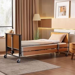 Ein leeres Krankenhausbett mit Rädern in einem gut beleuchteten Raum, neben einem Fenster mit Blick auf Bäume.