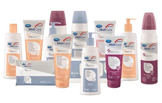 Eine Sammlung von Hautpflegeprodukten von MoliCare auf weißem Hintergrund, einschließlich Flaschen, Tuben und Verpackungen.