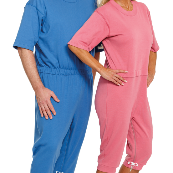 Ein Mann und eine Frau stehen eng beieinander. Der Mann trägt einen blauen Overall, die Frau einen rosafarbenen Overall.