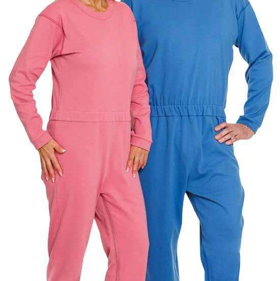 Eine Frau und ein Mann posieren in passenden Schlafanzügen, stehen eng beieinander, Hände auf den Hüften und lächeln.