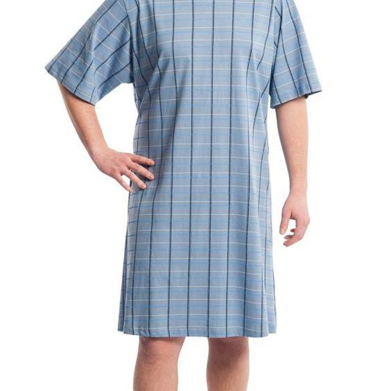 Ein Mann in einem hellblau karierten Hemd steht mit der Hand auf der Hüfte.