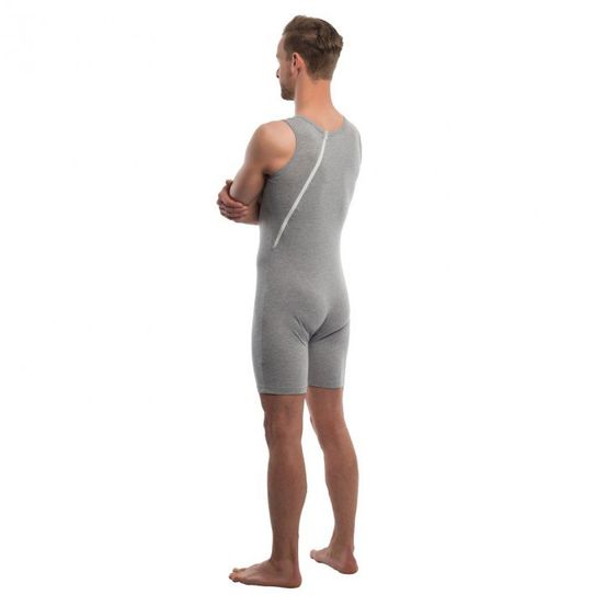 Ein Mann mit dem Rücken zur Kamera, der eine graue Shorts mit Reißverschluss trägt. Er hat die Arme hinter dem Rücken verschränkt.