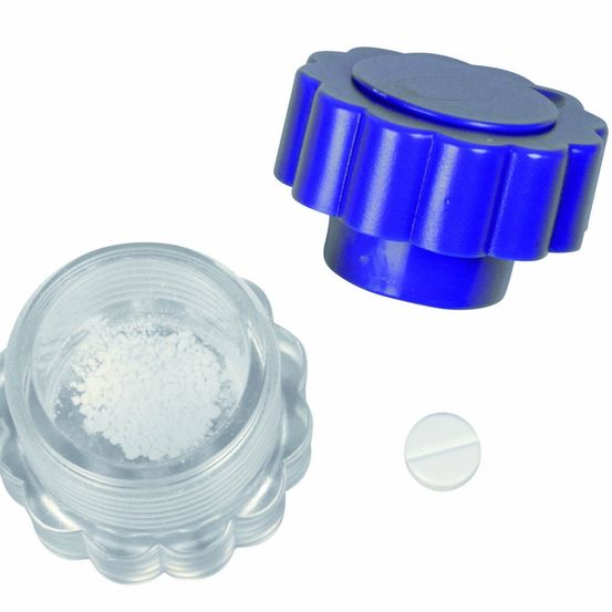 Ein blauer Plastikbehälter mit Deckel und einer kleinen weißen Pille auf weißem Hintergrund.