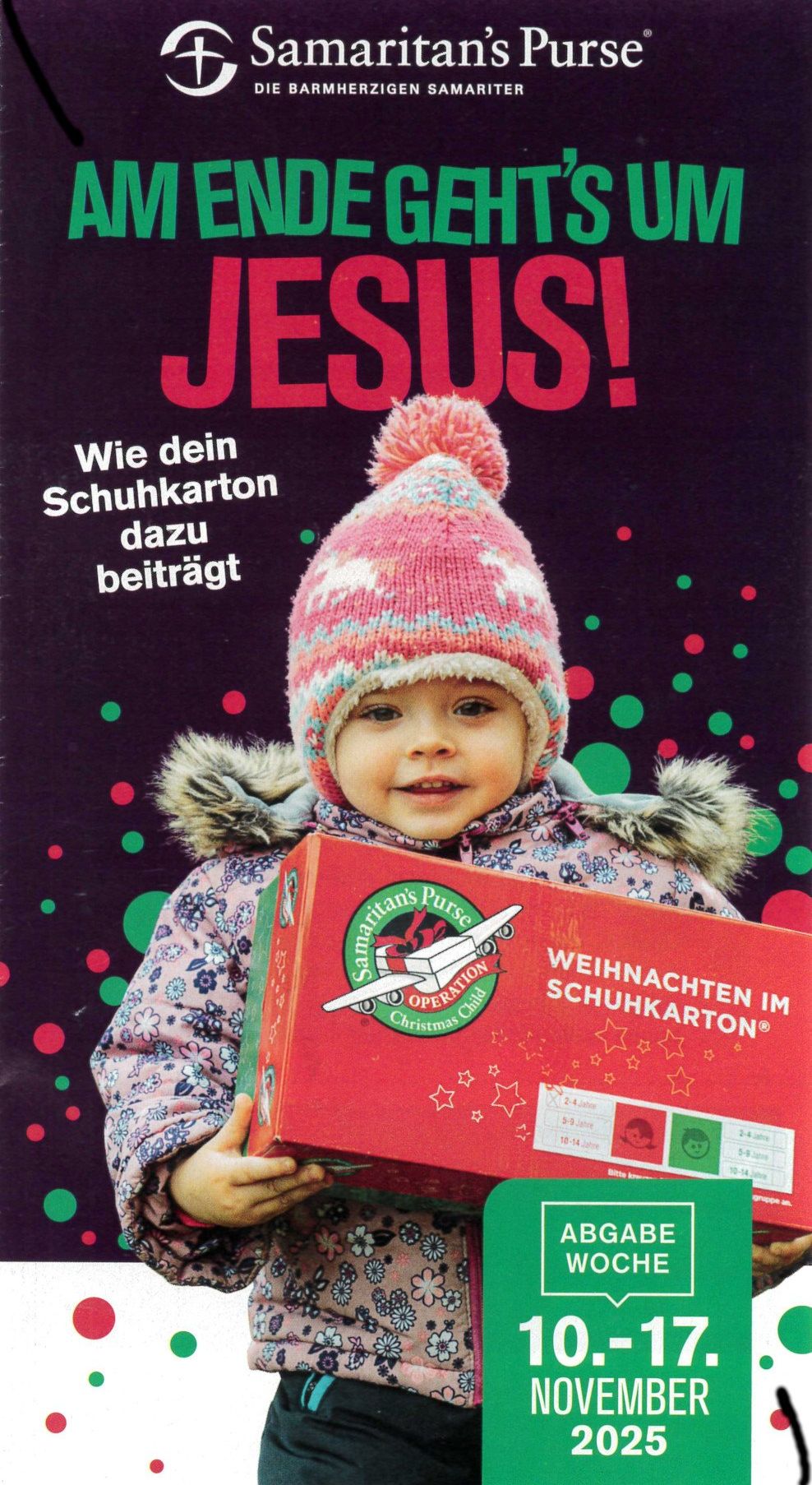 Ein Kind in einem Wintermantel und einer Mütze hält eine rote Schuhschachtel mit der Aufschrift 'Operation Christmas Child' und dem Wort 'JESUS!' darüber auf einem bunten Hintergrund.