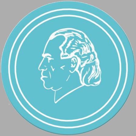 Ein blauer kreisförmiger Aufkleber mit weißem Umriss zeigt ein Profil des Gesichts eines Mannes. Der Mann hat kurze Haare und einen Schnurrbart.