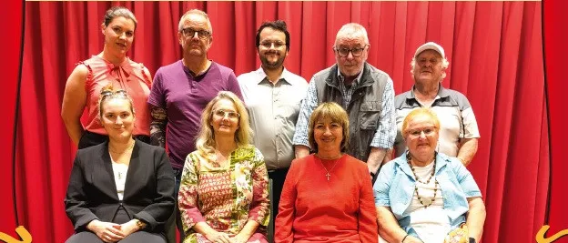 Ein Werbeplakat für eine Theateraufführung mit dem Titel 'Die paar Klunker' von der Martinihof Theatergruppe. Das Plakat zeigt eine Gruppe von Menschen, die vor einem roten Vorhang sitzen, mit Datum und Uhrzeit der Aufführungen aufgeführt.