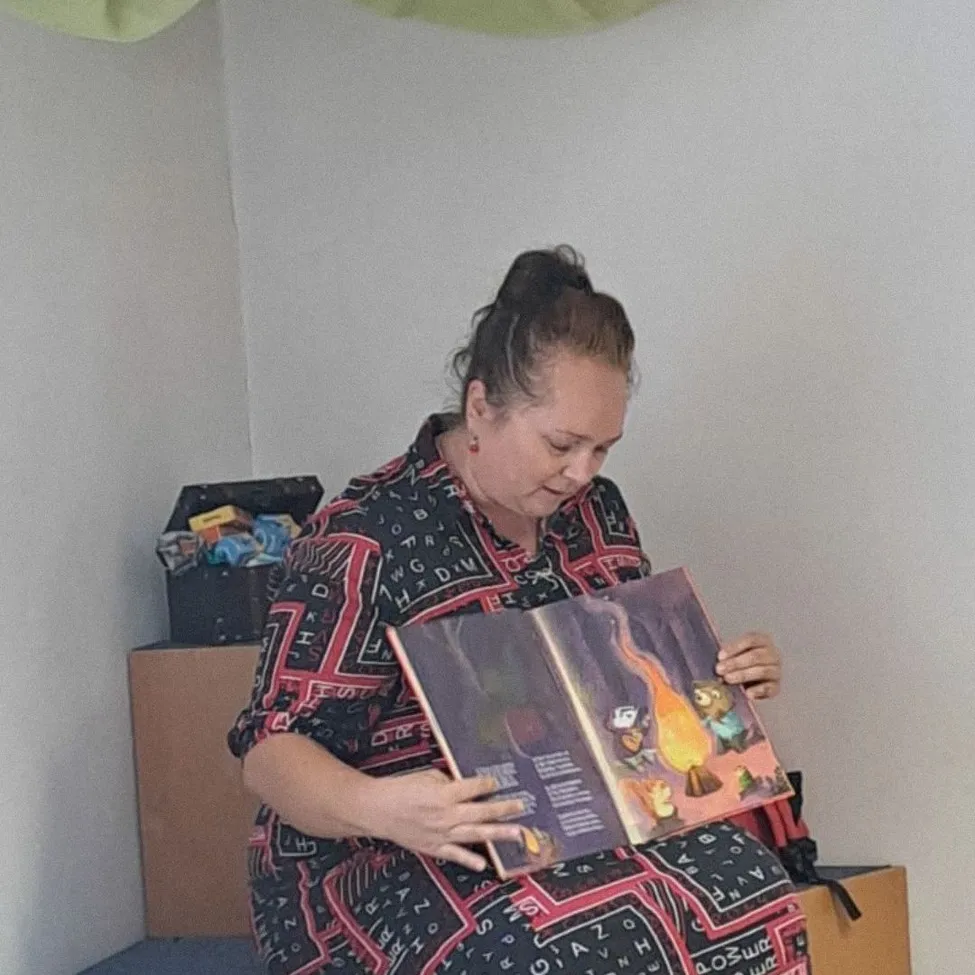Eine Frau sitzt auf einer Bank und liest ein Buch.