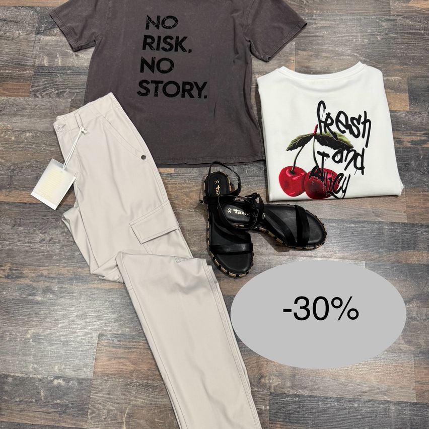 Ein Kleidungsset mit einem schwarzen T-Shirt, khakifarbenen Hosen, schwarzen Sandalen und einem weißen T-Shirt mit Kirschendesign. Ein Etikett ist an der Hose befestigt. Der Boden ist aus Holz. Es gibt ein 30% Rabattschild.