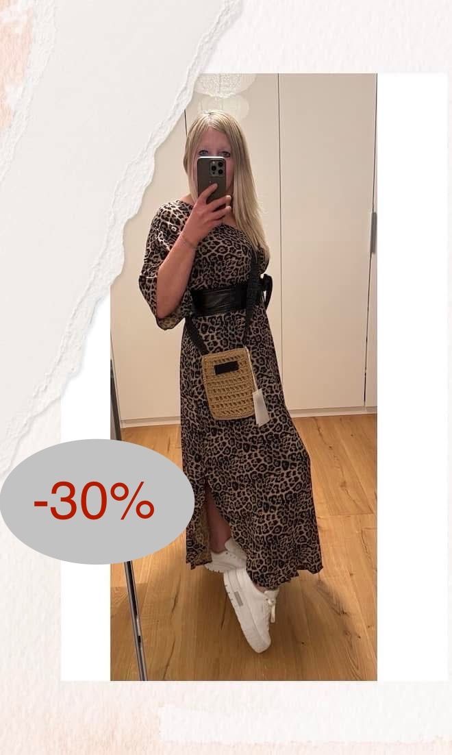 Eine Frau macht ein Selfie vor einem Spiegel. Sie trägt ein Leopardenmusterkleid mit einem schwarzen Gürtel und einer gehäkelten Tasche. Ein 30%iger Rabatt ist auf dem Bild angegeben.