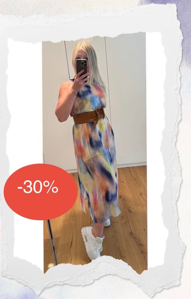 Eine Frau in einem farbenfrohen Tie-Dye-Kleid mit einem braunen Gürtel macht ein Selfie vor einem Spiegel. Im Hintergrund ist ein Holzboden und eine weiße Wand zu sehen. Ein roter Kreis mit dem Text -30% befindet sich links.