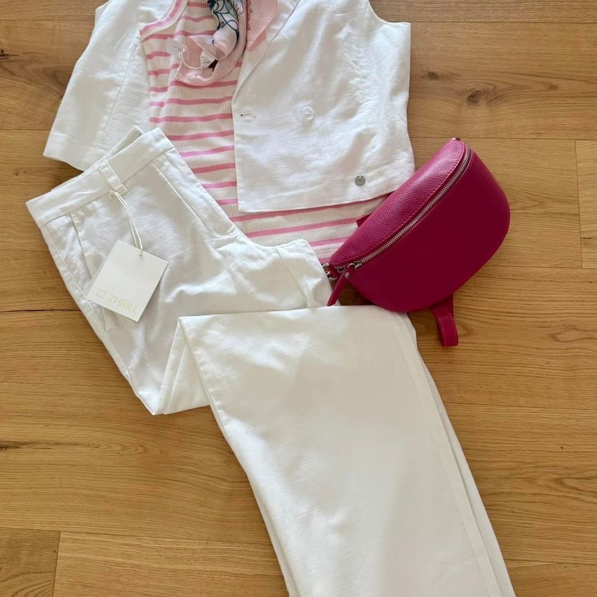 Weißes und rosa gestreiftes Kleidungsset mit Weste und einer rosa Tasche auf einem Holzboden.