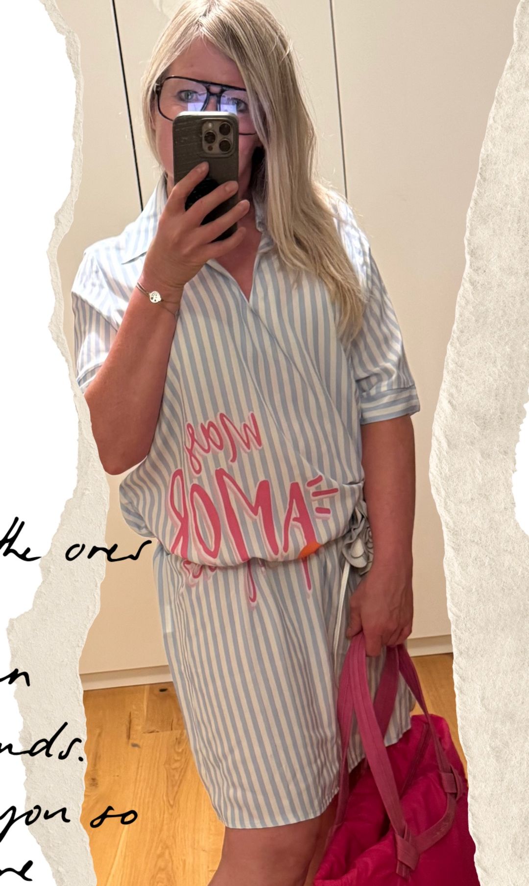 Eine Frau macht ein Selfie mit einem Shirt, auf dem in pink 'FROM ROMA' steht. Sie trägt ein Armband und hält eine rosa Tasche.