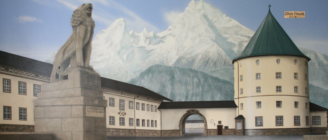 Eine gemalte Darstellung einer Löwenstatue, die nach links schaut, mit einem verschneiten Berg im Hintergrund. Ein Torbogen führt zu einem Gebäude mit vielen Fenstern und einer Uhr.