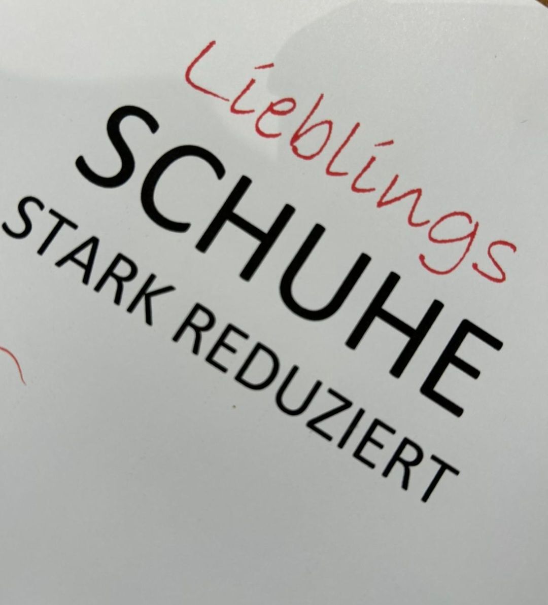 Ein weißes Papier mit fetter schwarzer Schrift, die 'STARK REDUZIERT' und 'SCHUHE LIEBLINGS' in rotem Farbton liest. 'STARK REDUZIERT' bedeutet 'stark reduziert'. Der Text 'SCHUHE' bedeutet 'Schuhe'.