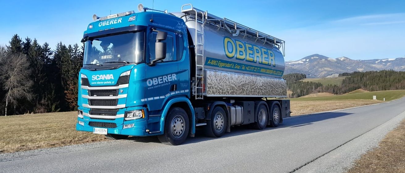Ein blauer Oberer-Lkw steht am Straßenrand. Er hat einen großen silbernen Tank auf der Rückseite mit dem Wort Oberer darauf.