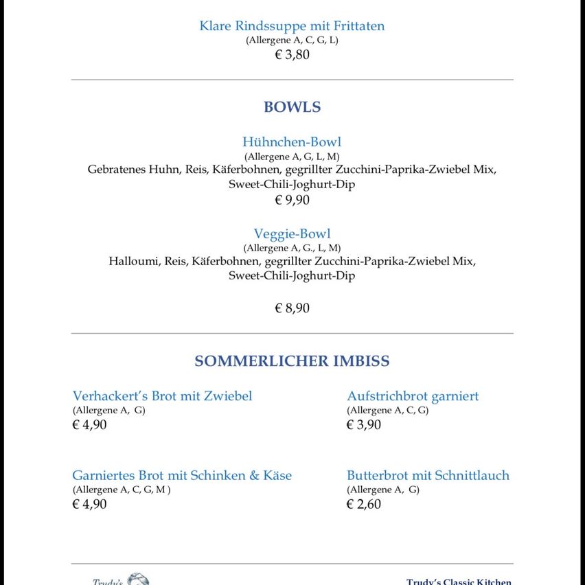 Ein Menü mit zwei Suppen und vier Sandwiches, jeweils mit Zutatenlisten und Preisen. Die Suppen umfassen Hühnchen- und Halloumi-Optionen, während die Sandwiches verschiedene Füllungen bieten. Die Preise reichen von €2,60 bis €9,90.