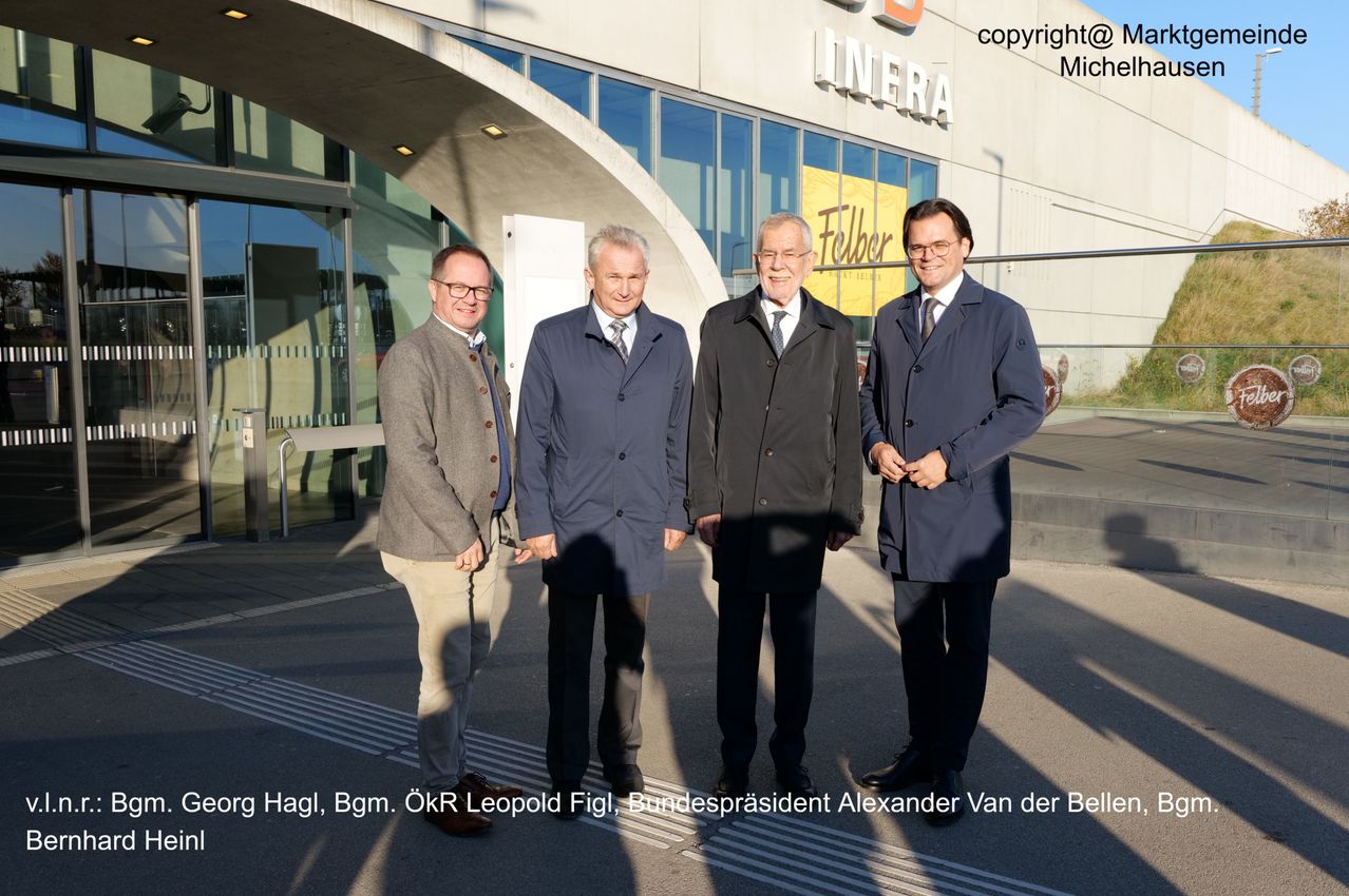 Vier Männer stehen vor einem Gebäude, wahrscheinlich bei einer Veranstaltung. Sie tragen alle Anzüge und Krawatten. Hinter ihnen befindet sich ein gelbes Schild mit der Aufschrift Folber.