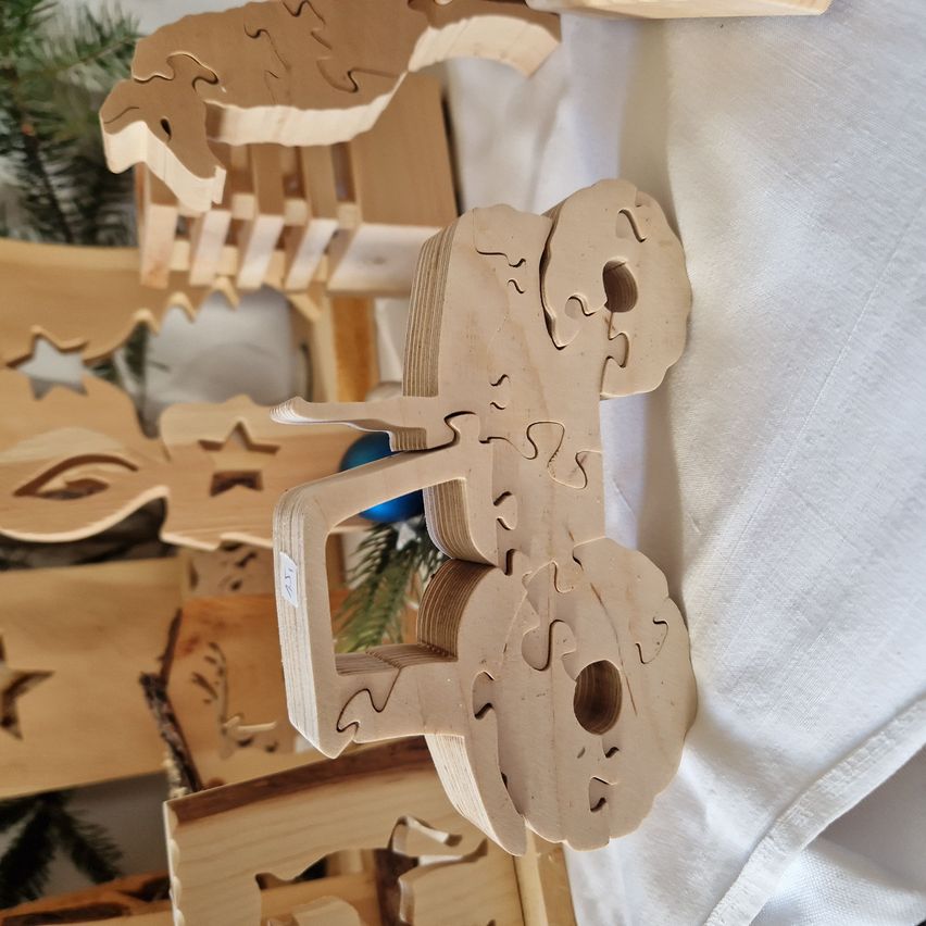 A close-up view of a wooden puzzle featuring a tractor, made from light-colored wood, with other wooden toys in the background.