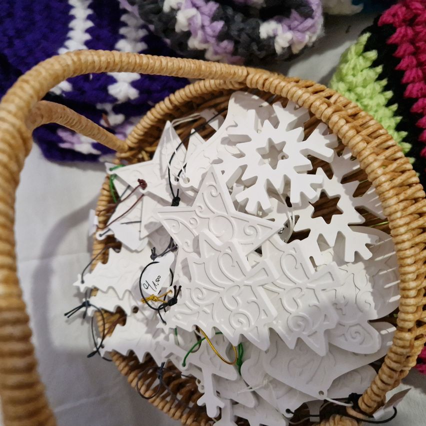 Ein Korb voller weißer, kunstvoll gestalteter Schneeflocken und Sterne. Jede Schneeflocke hat ein einzigartiges Muster.
