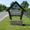 Ein Schild für Gruss Golf in St.Kathrein steht am Straßenrand, umgeben von Grün und einem Zaun.