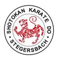 Das Logo für Shotokan Karate Do St. Egidius Stegersbach zeigt einen roten Tiger in der Mitte, umgeben von den Worten 'SHOTOKAN KARATE DO STEGERSBAC' in einem kreisförmigen Design.