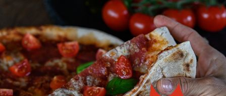 Advertisement for a pizza and pasta buffet. A hand holds a pizza slice. Price 13.90 for adults and 8.90 for kids.