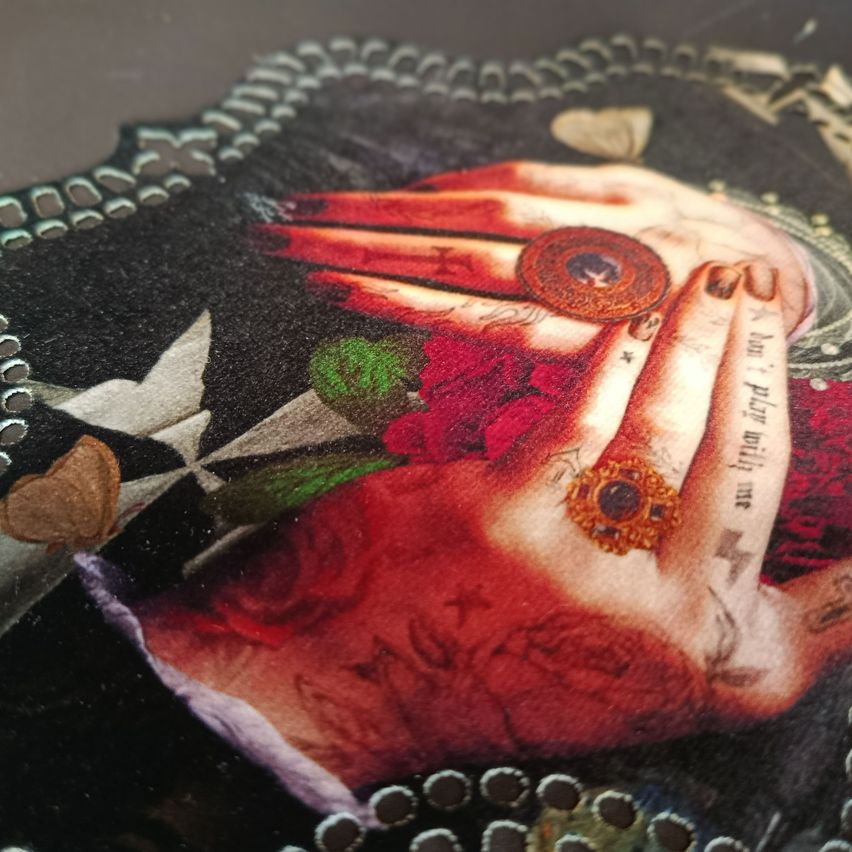 Nahaufnahme einer Hand, die rote Rosen mit aufwendigen Designs hält, einschließlich eines Rings und der Phrase 'Spiel mit mir' auf der Handfläche.