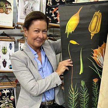 Bild enthält, Person, Clothing, Coat, Pants, Desk, Furniture, Table, Face, Head