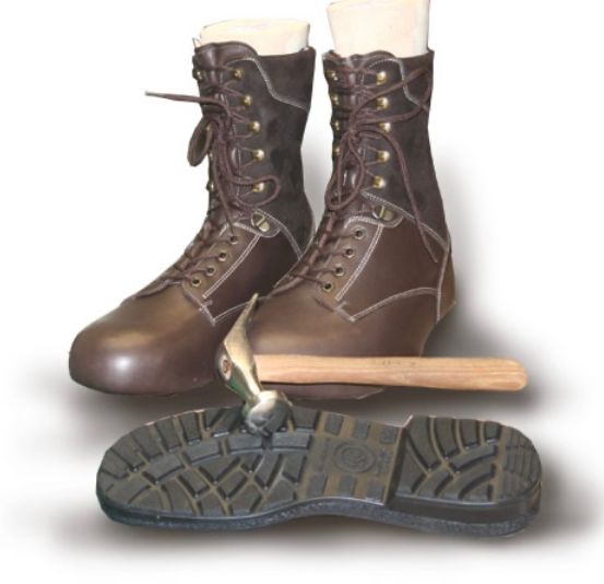 Zwei braune Lederstiefel mit Messingschnürsenkeln und einem Hammer auf einer Stiefelsohle mit einem Profilmuster.