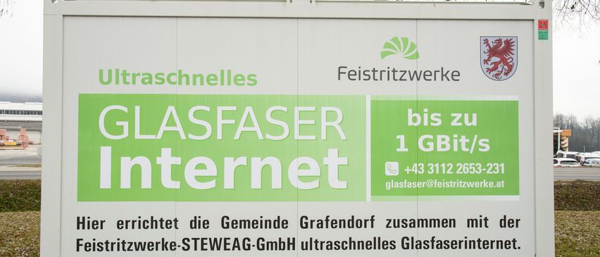 Ein Werbeschild für ultraschnelles Internet von Glasfaser Internet, das Geschwindigkeiten bis zu 1 GBit/s bietet, mit Kontaktinformationen und einer Gemeinschaftspartnerschaft mit Grafendorf und STEWEAG GmbH.