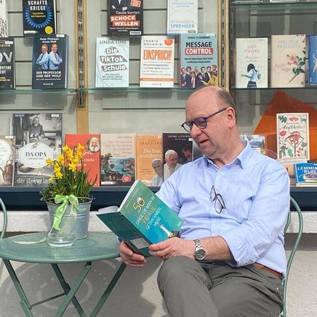 Bild enthält, Book, Publication, Person, Sitting, Adult, Male, Man, Plant, Reading, Face