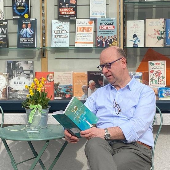 Bild enthält, Book, Publication, Person, Sitting, Adult, Male, Man, Plant, Reading, Face