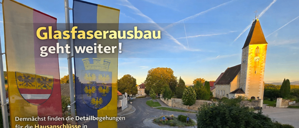 Ein Plakat zeigt ein deutsches Dorf mit einer Kirche und Flaggen. Es steht 'Glasfaserausbau geht weiter!' und listet Straßen auf, wo Hausanschlüsse gemacht werden. Es endet mit einem Daumen hoch.