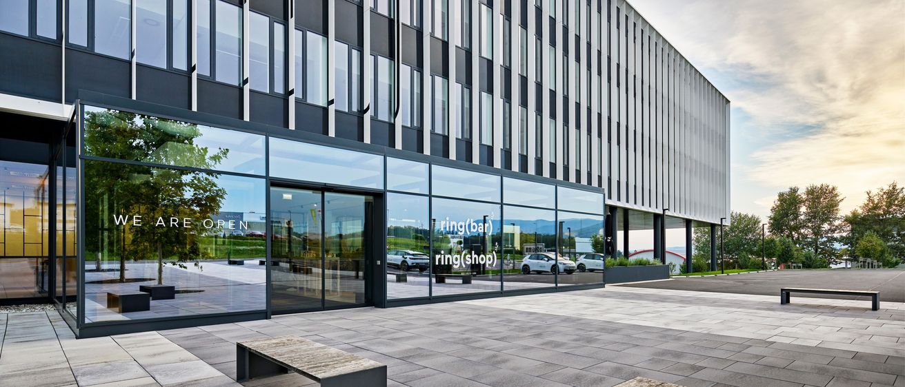 Bild enthält, Architecture, Building, Office Building, Car, Car Dealership, Transportation, Vehicle, Bench, Furniture