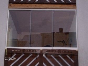 Ein Fenster mit weißem Rahmen und Glasscheiben ist zu sehen. Im Inneren spiegeln sich eine Holzstruktur und einige Objekte. Unten links ist das Datum 22/12/2009 zu erkennen.