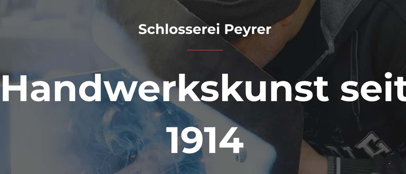 Ein Banner mit dem Text 'Schlosseerei Peyrer, werkskunst 1914.' Darunter befindet sich ein Teilbild einer Hand.