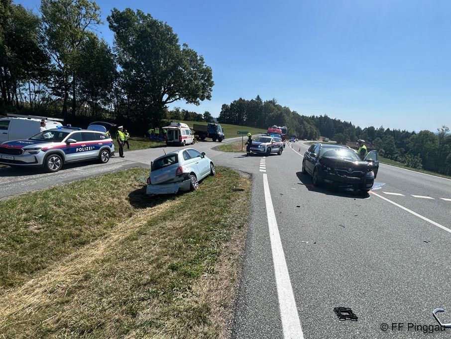 A car accident on a road with several vehicles involved, including police cars and an ambulance. The damaged cars are parked on the side of the road.