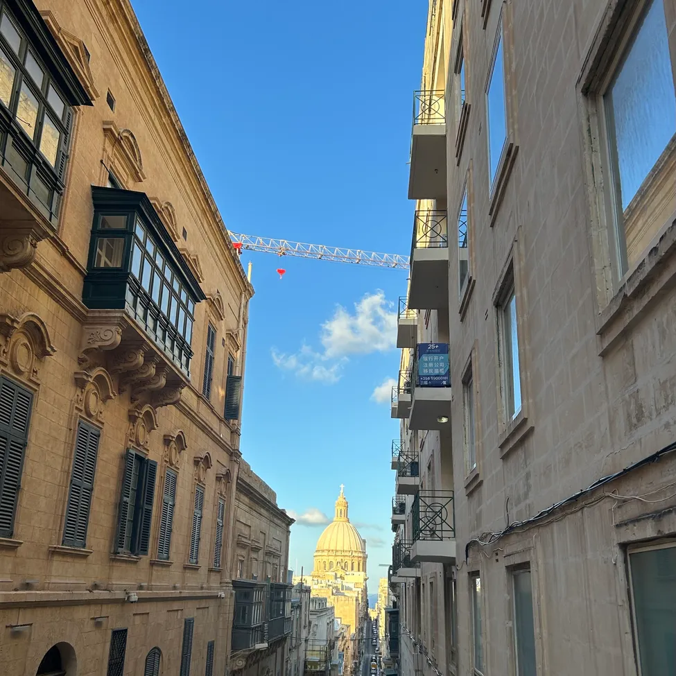 Ein Blick auf eine Stadt mit einem großen Gebäude auf der linken Seite und einem hohen Gebäude mit einer Kuppel auf der rechten Seite.