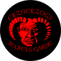 Ein kreisförmiges Emblem mit einem roten dämonischen Gesicht auf schwarzem Hintergrund. Der Text 'ERZHERZOGS TEUFELS GARDE' ist in roter gotischer Schrift um das Gesicht herum geschrieben.