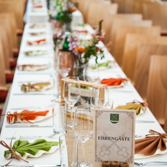 Bild enthält, Furniture, Table, Tabletop, Indoors, Dining Table, Cup, Restaurant, Flower, Flower Arrangement, Hall