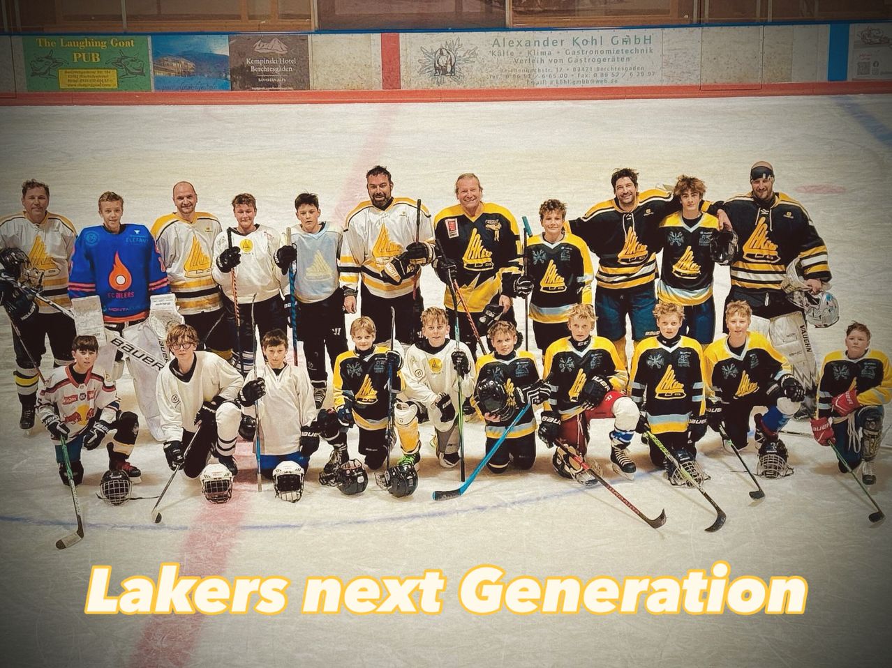 Eine Eishockeymannschaft posiert für ein Gruppenfoto auf einer Eisbahn mit einem Hintergrund, der Lakers Next Generation steht.